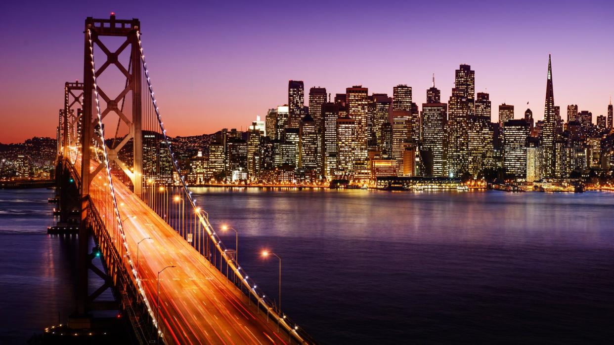 San Francisco skyline and Bay Bridge at sunset, California.