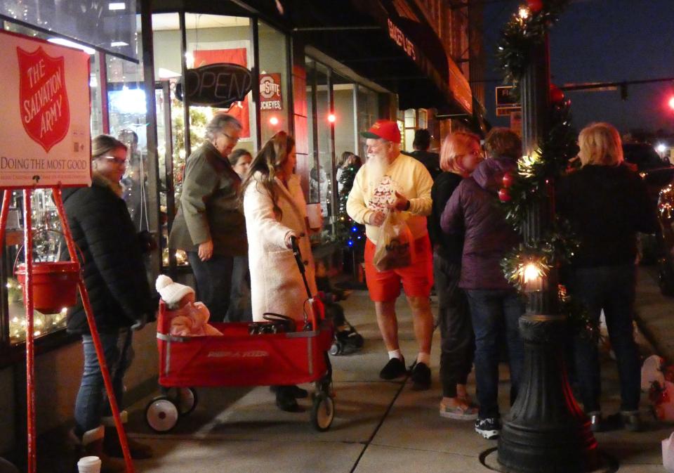 John Kuhn, center, makes his way down Sandusky Avenue during the Bucyrus Area Chamber of Commerce's annual Candlelight Christmas on Thursday evening.