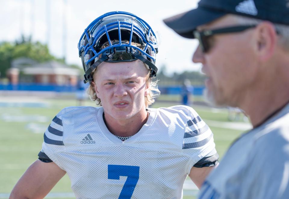 Franklin Community High senior Max Clark listens to head coach Chris Coll during practice on Wednesday, Aug. 17, 2022, in Indianapolis. 