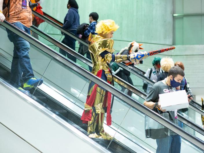 Man in costume for Anime convention on escalator.