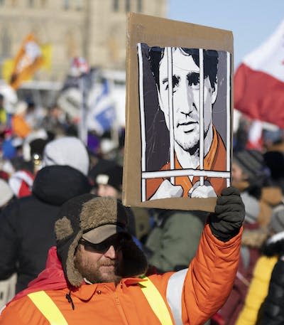 A protester holds an anti-Trudeau sign near Parliament Hill in Ottawa. THE CANADIAN PRESS/Adrian Wyld