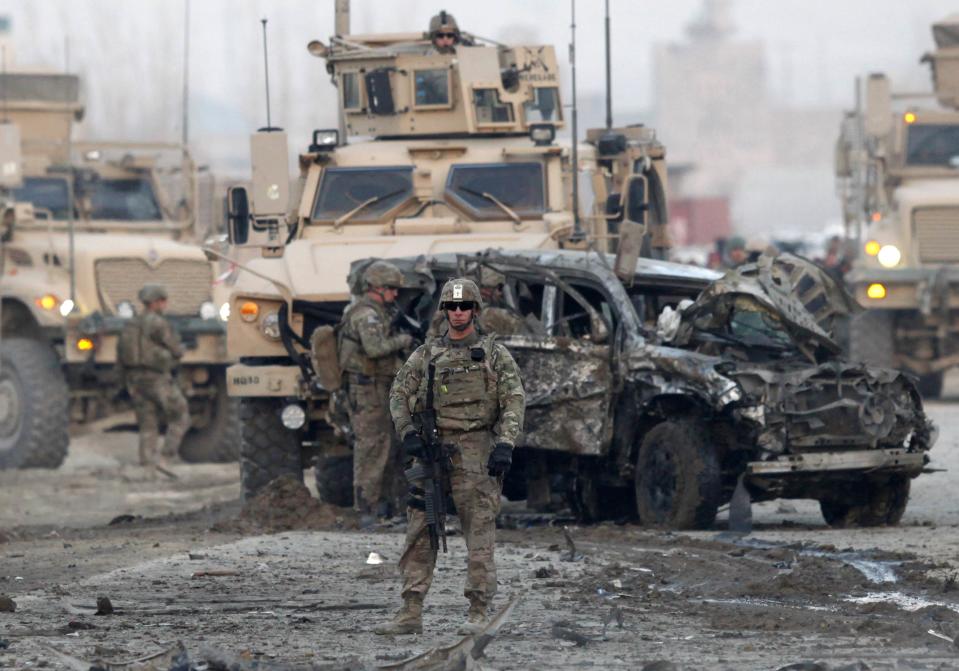 U.S. troops stand guard at the site of a suicide car bomb attack in Kabul