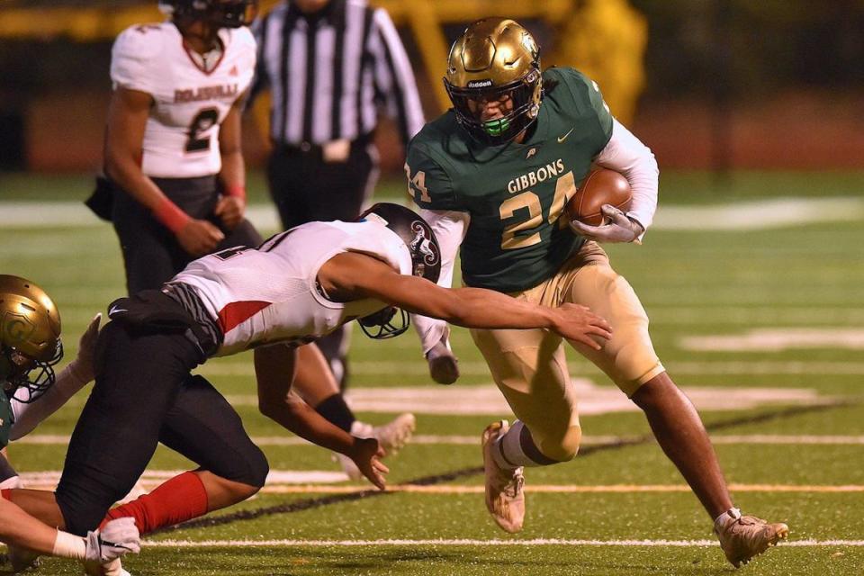 Cardinal Gibbons’ Ryan Ziegler (24) runs for the first down against Rolesville’s Jacorrey Bible (11) during the first quarter. The Cardinal Gibbons Crusaders and the Rolesville Rams met in the NCHSAA 4A East Regional Final in Raleigh, N.C. on December 3, 2021