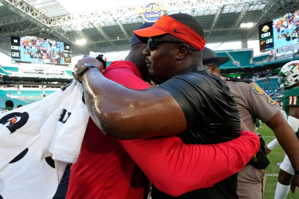 Jackson State head coach T.C. Taylor, left, and Florida A&M head coach Willie Simmons, right, embrace on the field after Florida A&M defeated Jackson State in the Orange Blossom Classic NCAA college football game, Sunday, Sept. 3, 2023, in Miami Gardens, Fla. (AP Photo/Lynne Sladky)