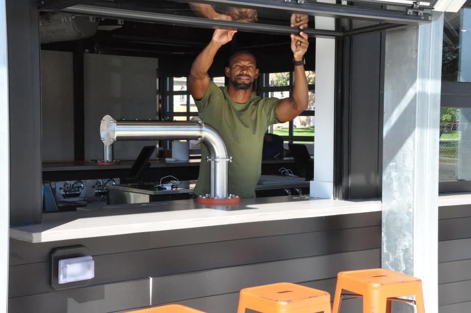 Co-owner Donny Legans opens the windows at the bar area at Rail Haus beer garden, 92 N. West St., Dover. The windows can be raised in good weather at the indoor-outdoor restaurant or closed during bad weather when all the customers are inside.