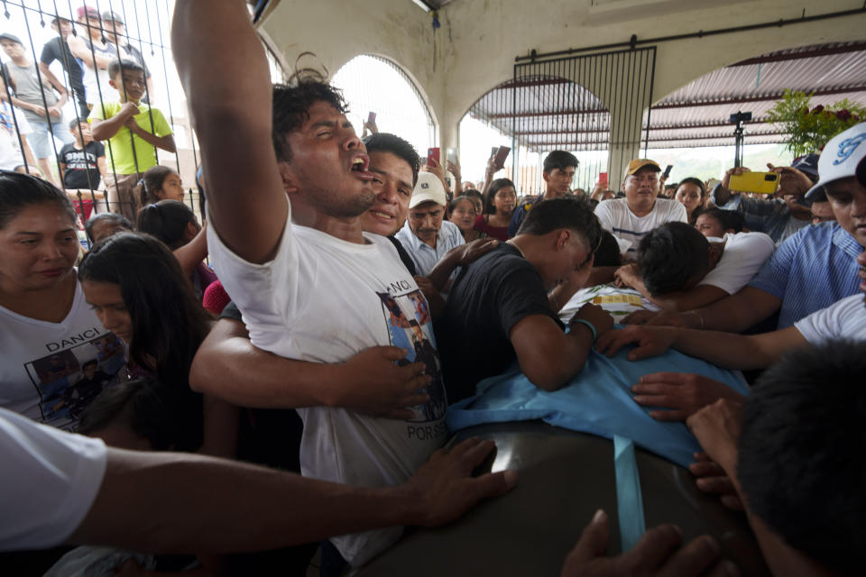 Familiares desconsolados en el entierro de los migrantes guatemaltecos Francisco Rojché y Miguel Rojché en Chicacao, Guatemala, el miércoles 12 de abril de 2023. Los dos hombres murieron en un incendio cuando estaba encerrados en un centro de detención de migrantes mexicano en Ciudad Juárez. (AP Foto/Moisés Castillo)