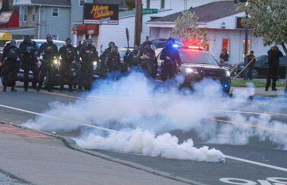 Akron police and sheriff's deputies deploy smoke bombs and tear gas to disperse a crowd at an April 19 protest on Copley Road in Akron.