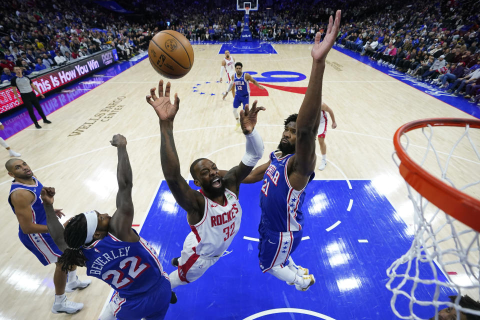 Houston Rockets' Jeff Green (32) goes up for a shot between Philadelphia 76ers' Joel Embiid (21) and Patrick Beverley (22) during the first half of an NBA basketball game, Monday, Jan. 15, 2024, in Philadelphia. (AP Photo/Matt Slocum)