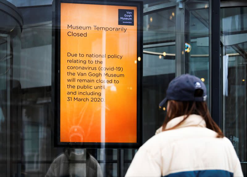 A tourist looks at an announcement that the Van Gogh Museum is closed because of the coronavirus outbreak