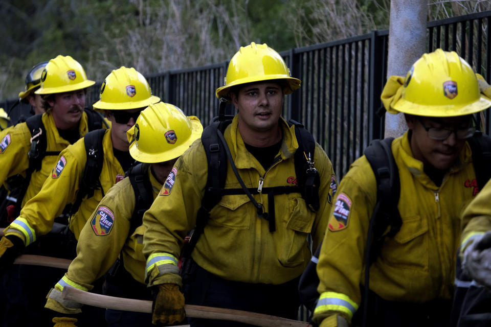 Members of the Hotshots fire crew walk in line during a wildfire in the Pacific Palisades area of Los Angeles, Sunday, May 16, 2021. (AP Photo/Ringo H.W. Chiu)