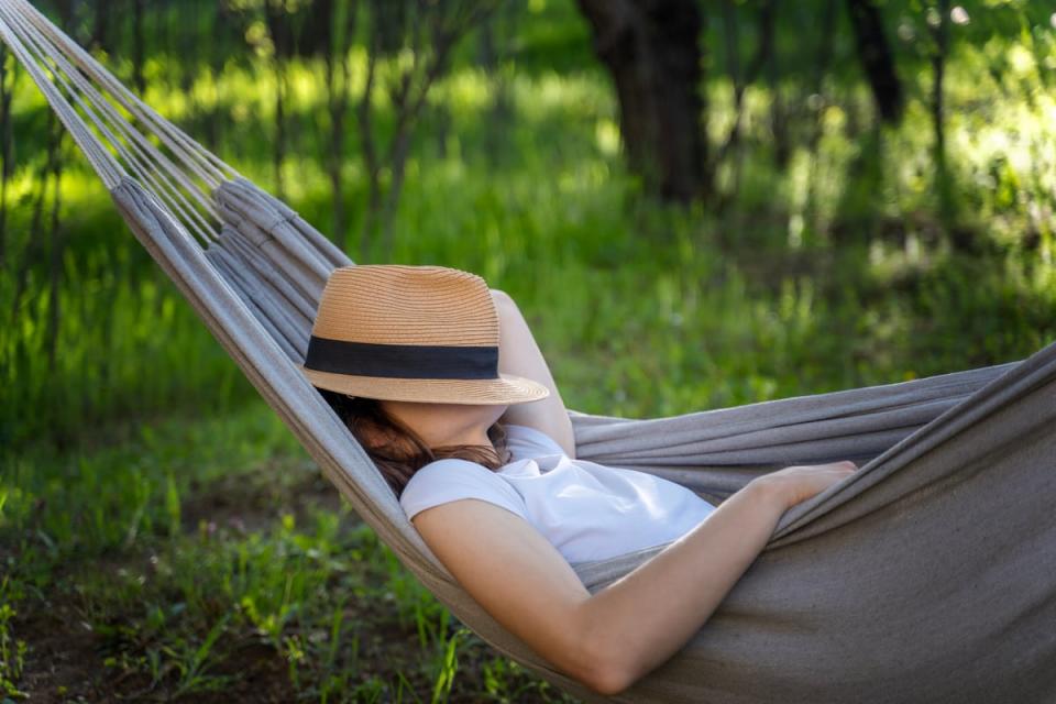 A person sleeping in a hammock.