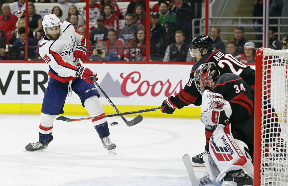 Washington Capitals' Brett Connolly (10) shoots and scores against Carolina Hurricanes goalie Petr Mrazek (34), of the Czech Republic, while Hurricanes Sebastian Aho (20), of Finland, defends during the first period of Game 6 of an NHL hockey first-round playoff series in Raleigh, N.C., Monday, April 22, 2019. (AP Photo/Gerry Broome)