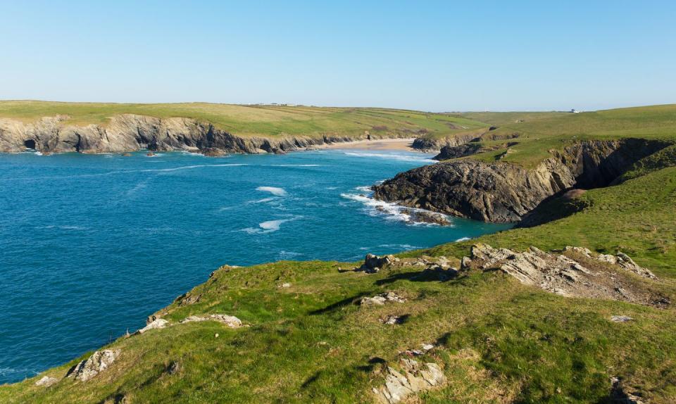 <p>Situated in a deep cove between headlands, Porth Joke is as unspoiled as they come. The narrow beach here is deeper than it is wide and backs onto a shallow valley with a stream running down, meaning it's perfect for sitting back against the rocks for a bit of shelter.</p>