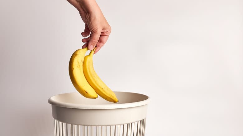 Person throwing away banana