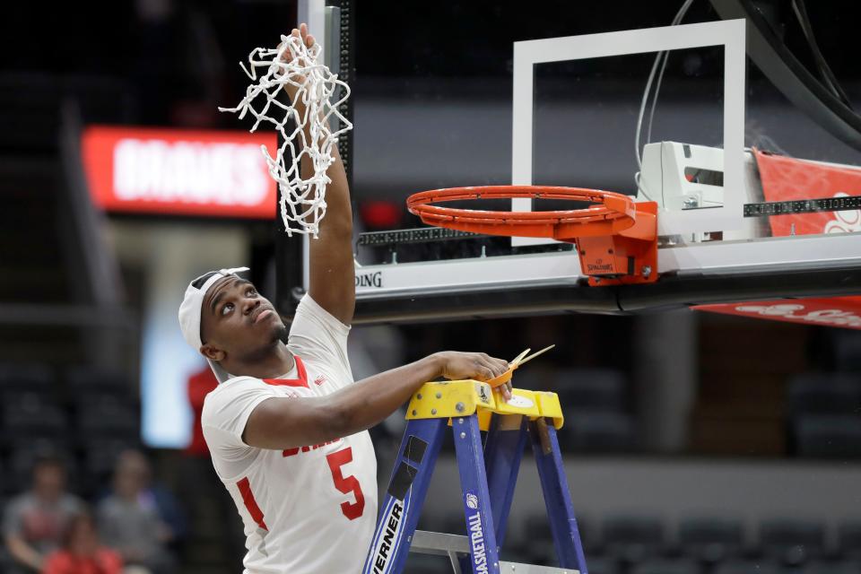 Bradley's Darrell Brown Jr. cuts down the net in celebration after the Braves defeated Valparaiso 80-66 in the championship of the Missouri Valley Conference men's tournament Sunday in St. Louis. [AP Photo/Jeff Roberson]