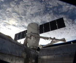 The privately built SpaceX Dragon cargo capsule is moved into its final position on the International Space Station's Harmony module with a bright Earth in the background in this view captured during the capsule's March 3, 2013, docking. The Dr