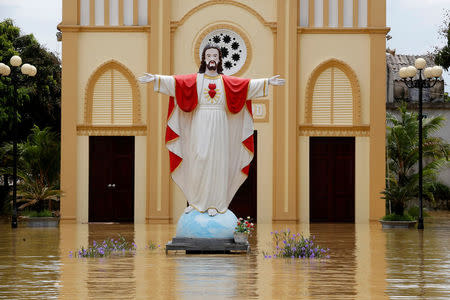 A submerged statue of Jesus is seen at a flooded village after heavy rainfall caused by tropical storm Son Tinh in Ninh Binh province, Vietnam. REUTERS/Kham