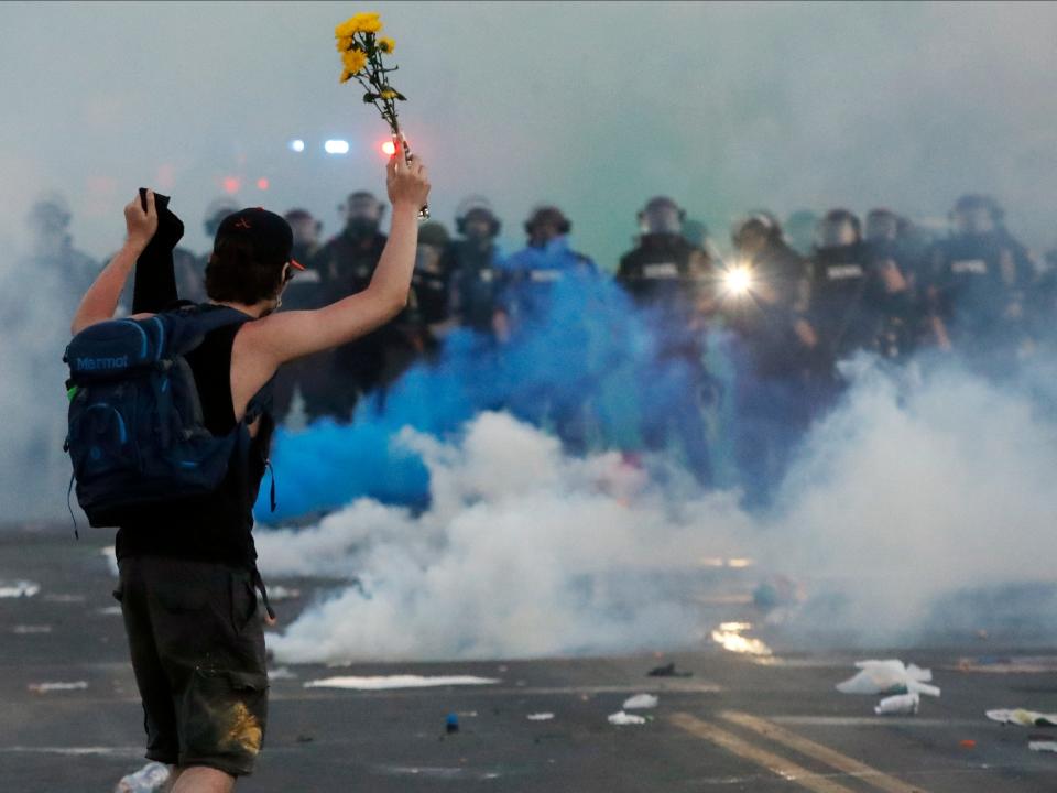 Police move towards a protester after curfew Saturday, May 30, 2020, in Minneapolis. Protests continued following the death of George Floyd, who died after being restrained by Minneapolis police officers on Memorial Day. (AP Photo/John Minchillo)
