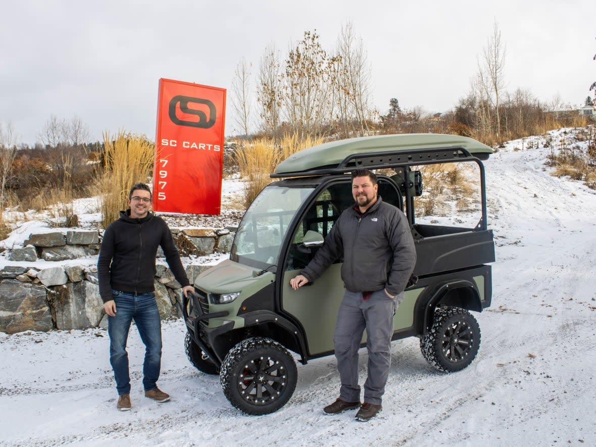 Jeff Holomis, CEO and owner of Vernon-based SC Carts, left, and production manager Lee Waters flank a City-W model currently being completed for a customer. The company's low-speed EVs are street-legal and have a top speed of 40 km/h. (SC Carts - image credit)