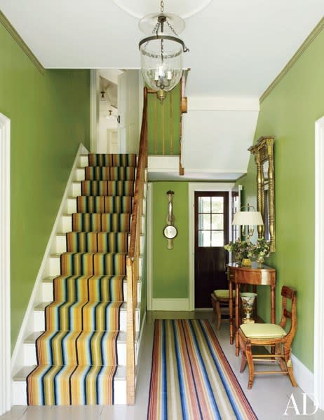 Apple-green walls and striped runners by Woodard & Greenstein compliment the painted stairs in the entrance hall in Craig Fitt and decorator Bruce Shostak’s <span>Federal-era house</span> in Claverack, New York.