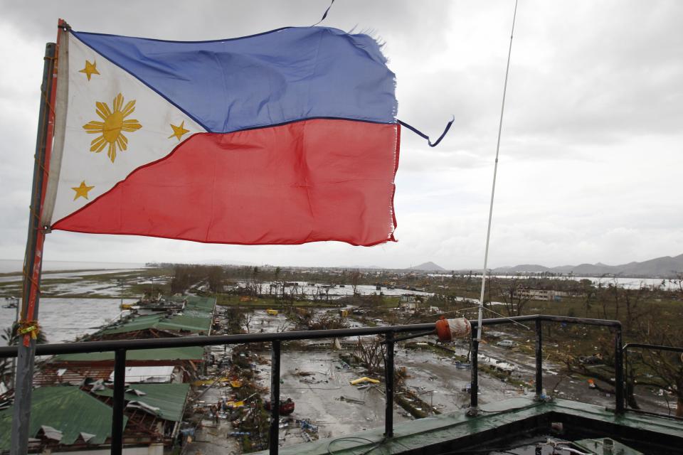 A Philippine flag flutters atop the control tower of a damaged airport after super Typhoon Haiyan battered Tacloban city