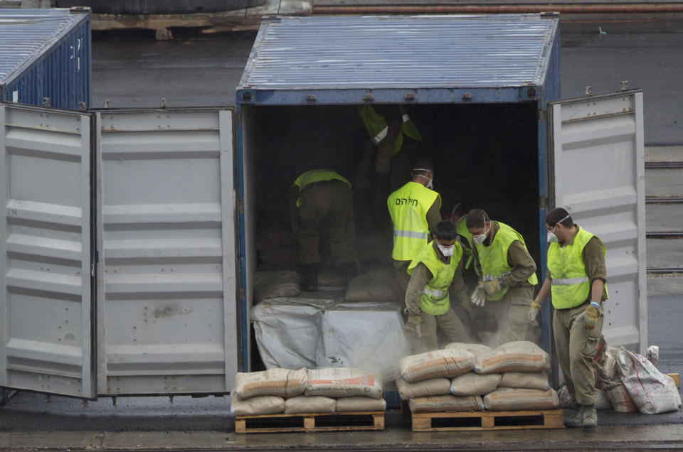 Israeli soldiers unload cement bags from a seized Klos-C cargo ship's container in the military port at the Red Sea resort city of Eilat, southern Israel, Sunday, March 9, 2014. Israel's Prime Minister Benjamin Netanyahu is calling on the European Union's foreign policy chief, Catherine Ashton, currently visiting Tehran, to confront Iranian officials about the weapons Israel says it caught last week en route from Iran to militants in Gaza. Ashton is in Tehran to further negotiations with Iran about its nuclear program. (AP Photo/Ariel Schalit)