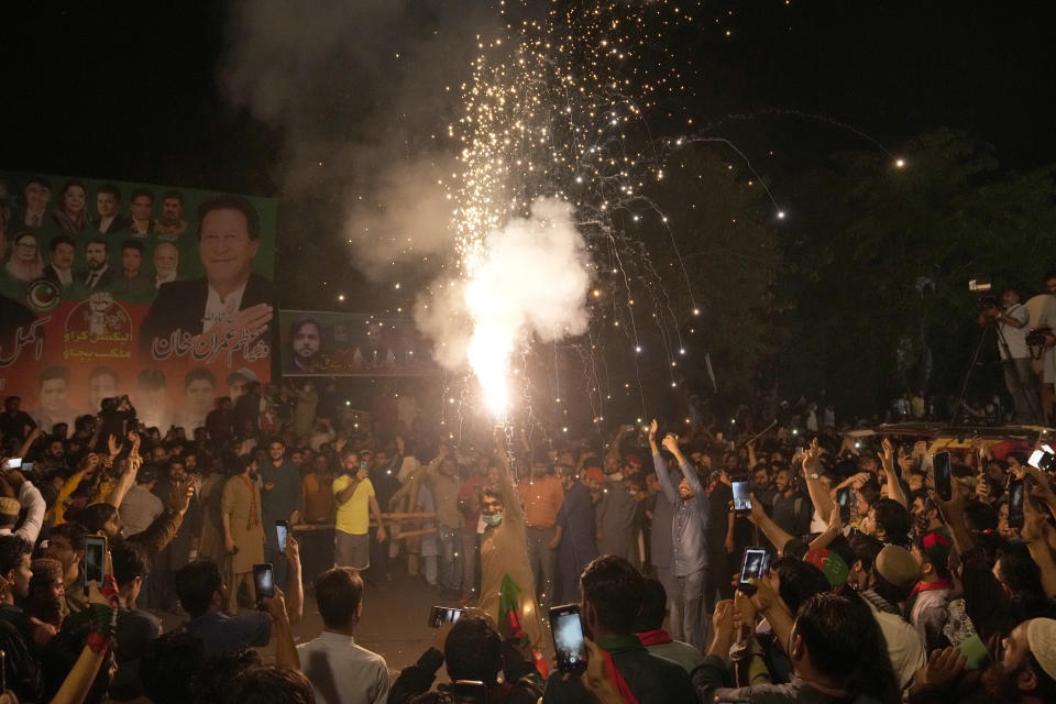 Supporters of former Prime Minister Imran Khan hold firework to celebrate their leader's release at outside his home in Lahore, Pakistan, Saturday, May 13, 2023. A high court in Islamabad on Friday granted Khan protection from arrest in a graft case and ordered him freed on bail. (AP Photo/K.M. Chaudary)