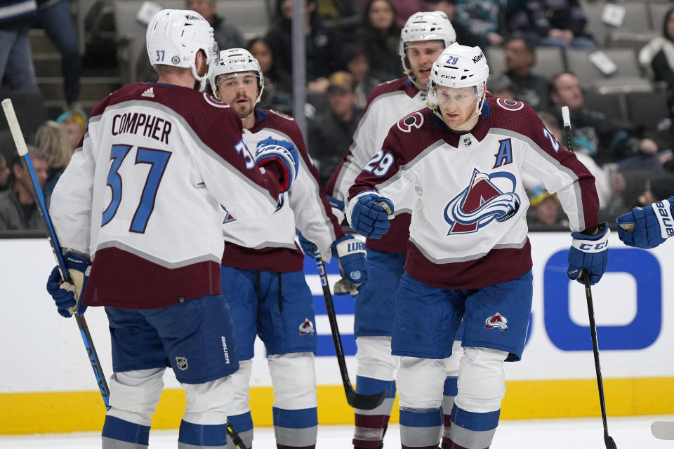 Colorado Avalanche center Nathan MacKinnon (29) gets a fist bump from J.T. Compher (37) after scoring a goal against the San Jose Sharks during the second period of an NHL hockey game Tuesday, April 4, 2023, in San Jose, Calif. (AP Photo/Tony Avelar)