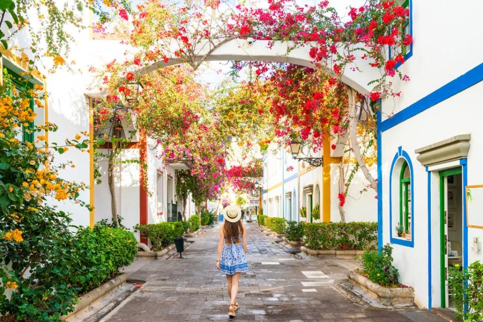 Mujer caminando rodeada de flores 