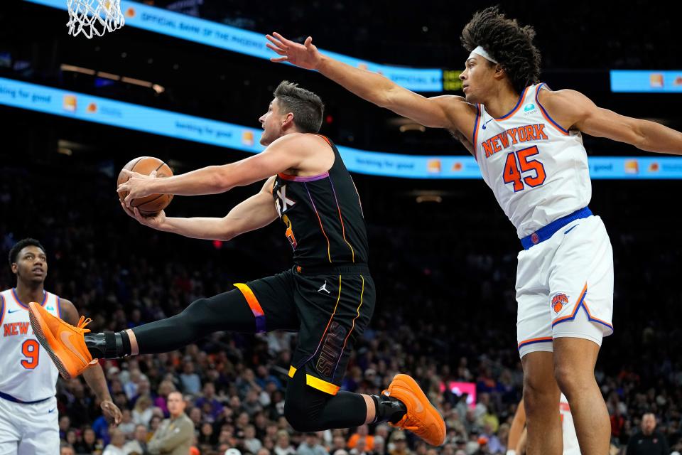 Phoenix Suns guard Grayson Allen drives past New York Knicks center Jericho Sims (45) during the first half of an NBA basketball game, Friday, Dec. 15, 2023, in Phoenix.