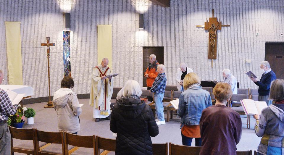 The Rev. Thomas Tyler, back left, leads a morning Mass at Holy Cross Catholic Church in Fairview Township on April 19. The Catholic Diocese of Erie is launching a restructuring plan to address declining population and a priest shortage throughout the 13-county diocese.