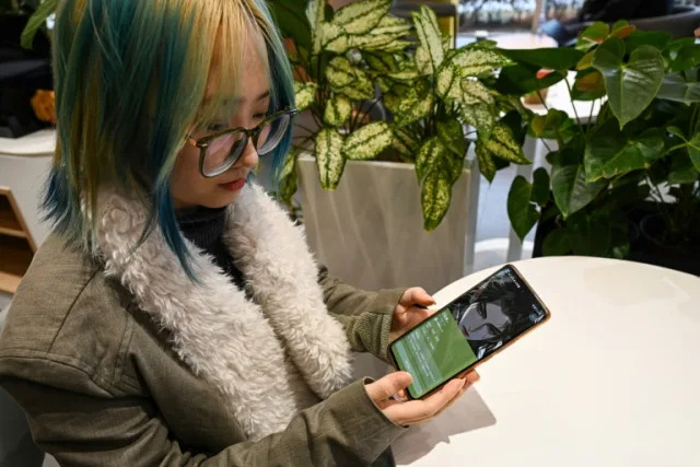 Wang Xiuting talks to her virtual boyfriend on Wantalk - an artificial intelligence chatbot created by Chinese tech company Baidu, on her phone at a cafe in Beijing (Jade GAO)