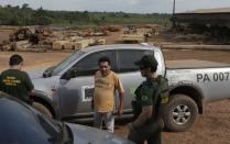 Joao Pereira (C), owner of a sawmill, talks with agent Paulo Maues of Brazil's Institute for the Environment and Renewable Natural Resources, or IBAMA, during a sting operation against sawmills, log haulers and loggers who trade in illegally extracted wood from the Alto Guama River indigenous reserve in Viseu, Para state, September 26, 2013. Picture taken September 26, 2013. To match Special Report BRAZIL-DEFOREST/ REUTERS/Ricardo Moraes (BRAZIL - Tags: ENVIRONMENT CRIME LAW POLITICS BUSINESS)