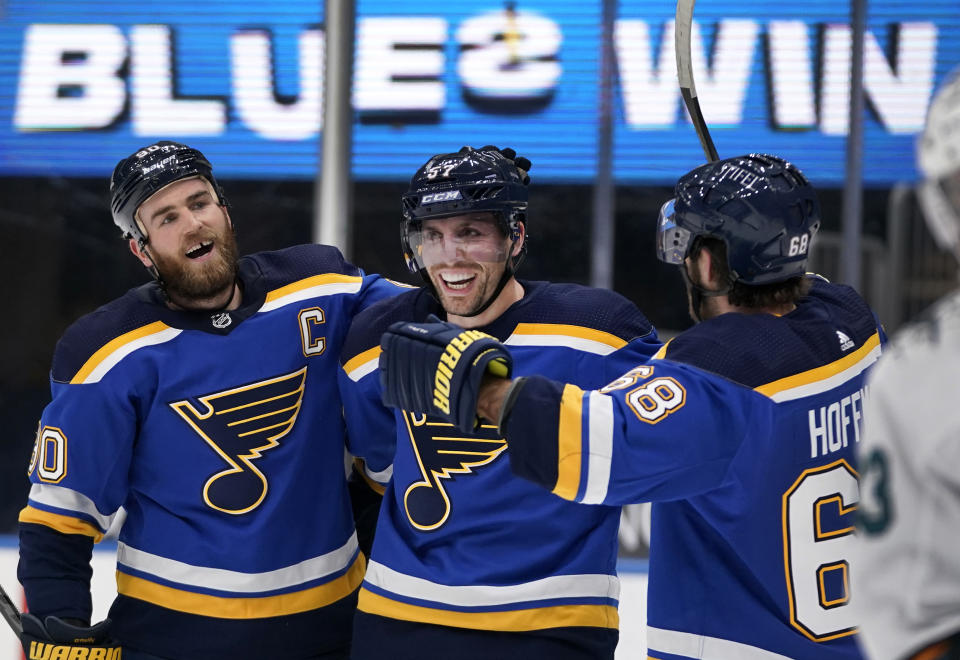 St. Louis Blues' David Perron is congratulated by teammates Ryan O'Reilly, left, and Mike Hoffman, right, after scoring the game-winning goal during overtime of an NHL hockey game against the San Jose Sharks Thursday, Feb. 18, 2021, in St. Louis. (AP Photo/Jeff Roberson)