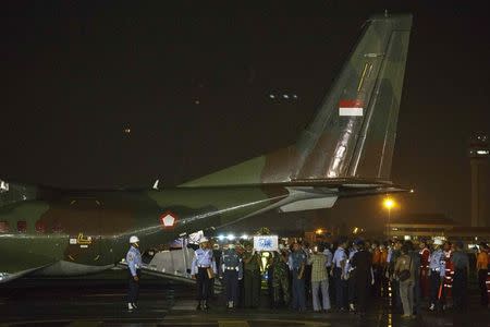 Indonesian military personnel carry caskets containing the remains of passengers onboard AirAsia flight QZ8501, recovered off the coast of Borneo, at a military base in Surabaya January 2, 2015. REUTERS/Athit Perawongmetha