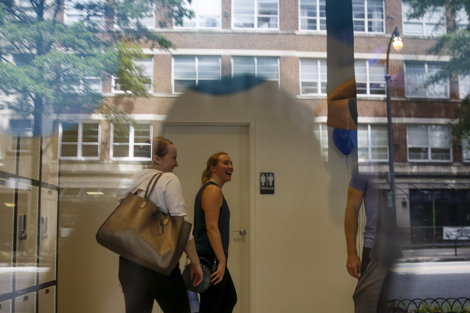 Morgan Colburn, 29, center, and Victoria Barley, 28, left, leave CITYROW Atlanta Midtown, after a workout as gyms reopen with limited members on Saturday, May 16, 2020, amid the COVID-19 virus in Atlanta. Big box gyms and local fitness studios are reopening under a patchwork of protocols based on state and local guidance, but most are following some basic protocol. (AP Photo/Brynn Anderson)