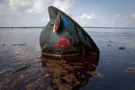 A hard hat from an oil worker lies in oil from the Deepwater Horizon oil spill on East Grand Terre Island, Louisiana, June 8, 2010. REUTERS/Lee Celano