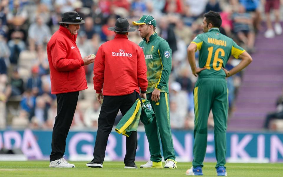 The umpires confront AB De Villiers over the state of the ball - Rex Features