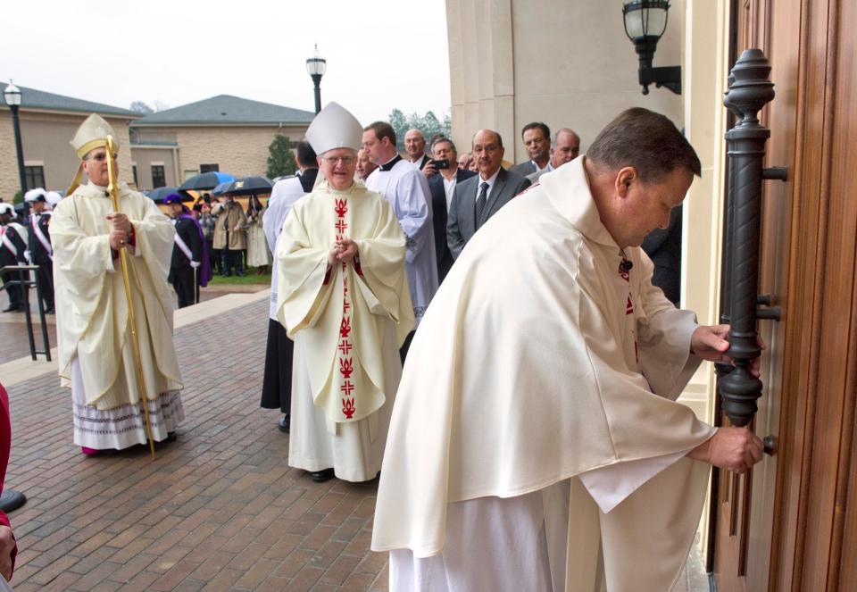 In this photo from 2014, the Rev. Michael Ingram, pastor of St. Teresa of Avila Catholic Church, officially opens the doors to the new parish church for the first time as Diocese of Savannah Bishop Gregory Hartmayer (left) and Bishop Emeritus Kevin Boland look on.