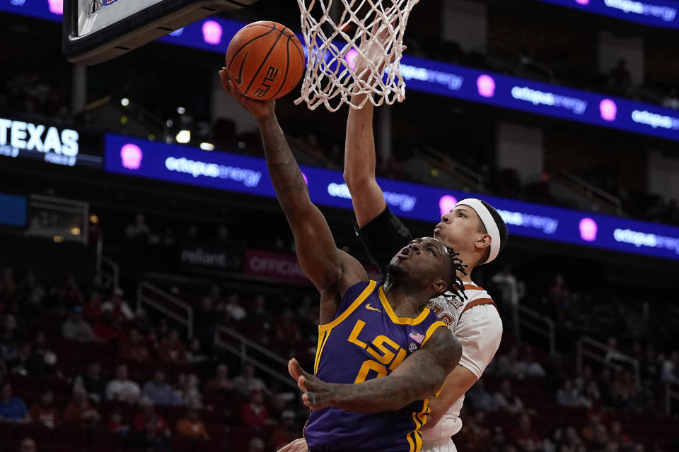 LSU guard Trae Hannibal (0) drives past Texas forward Kadin Shedrick (5) during the second half of an NCAA college basketball game, Saturday, Dec. 16, 2023, in Houston. (AP Photo/Kevin M. Cox)