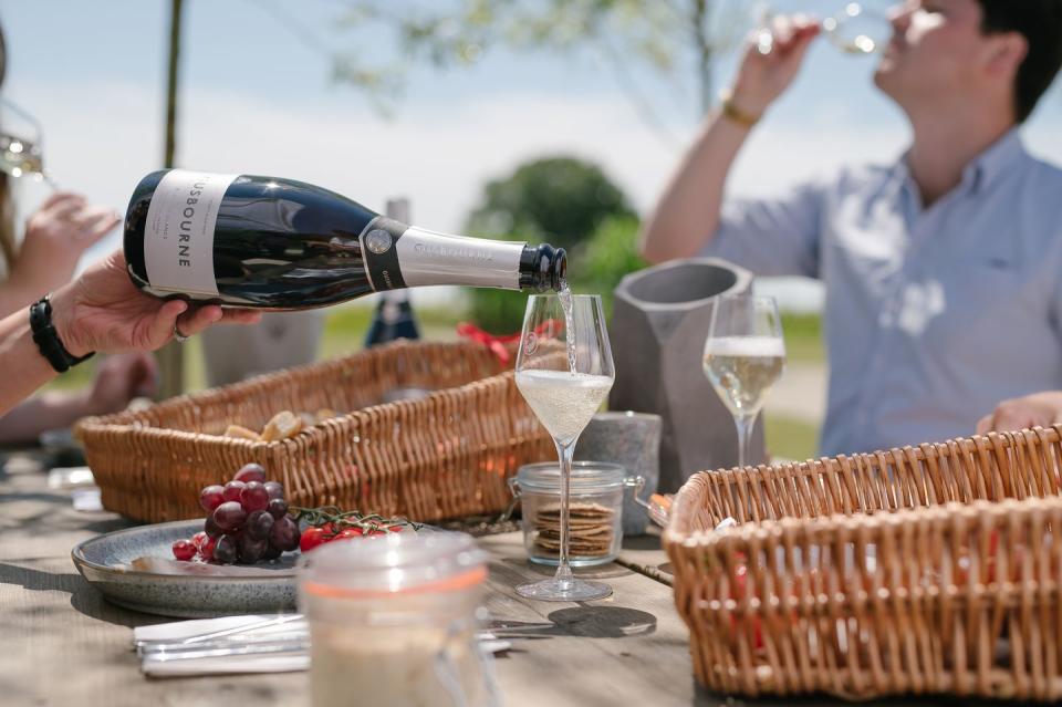 a person pouring wine into a glass