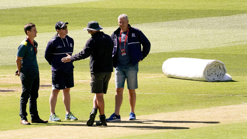 Pictured here, MCG staff discuss the situation that led to a Sheffield Shield match being abandoned.