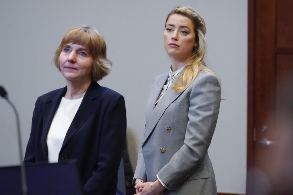 Actor Amber Heard stands with her attorney attorney Elaine Bredehoft in the courtroom at the Fairfax County Circuit Courthouse in Fairfax, Va., Friday, May 27, 2022. Actor Johnny Depp sued his ex-wife Amber Heard for libel in Fairfax County Circuit Court after she wrote an op-ed piece in The Washington Post in 2018 referring to herself as a "public figure representing domestic abuse." (AP Photo/Steve Helber, Pool)