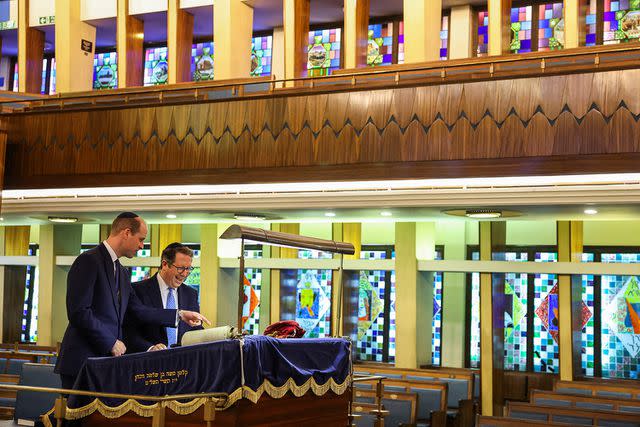 <p>TOBY MELVILLE/POOL/AFP via Getty Images</p> Rabbi Daniel Epstein shows Britain's Prince William, Prince of Wales a 17th century Torah scroll during a visit to the Western Marble Arch Synagogue, in London, on February 29.