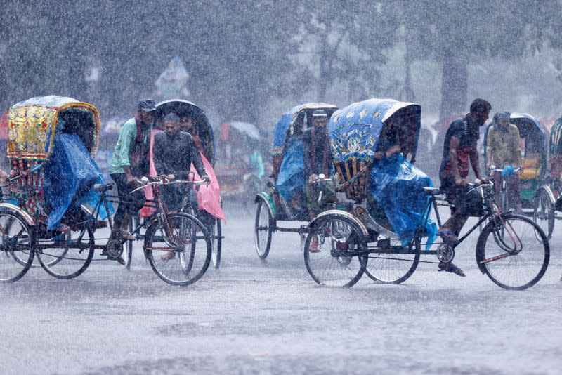 Rickshaws are seen during heavy rains in Dhaka