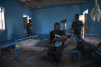 Tigrayan refugee Abraha Kinfe Gebremariam, 40, feeds his 4-month old daughter, Aden, inside their shelter in Hamdayet, eastern Sudan, near the border with Ethiopia, on March 21, 2021. Their village of Mai Kadra was the first known massacre of a conflict in which thousands of ethnic Tigrayans like his family have been killed. (AP Photo/Nariman El-Mofty)