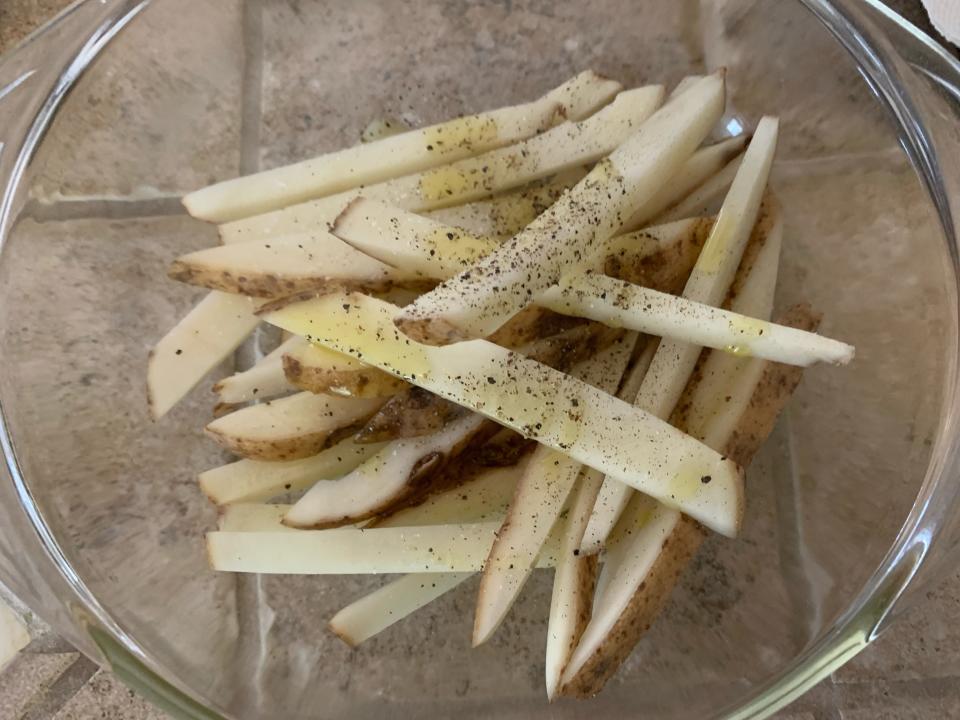 Chopped potatoes in a bowl with olive oil and pepper