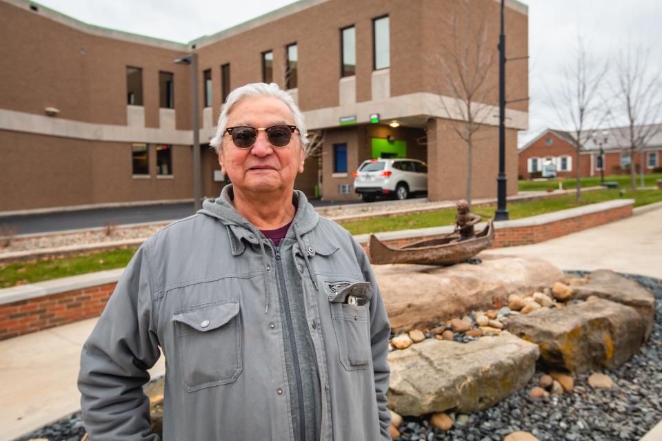 Peter B. Jones stands near "River Trade," the bronze statue he created for downtown Cuyahoga Falls