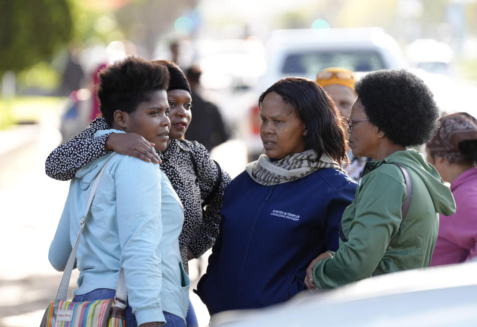 A relative, left, of a trapped person, is consoled at the site of a building collapse in George, South Africa, Wednesday, May 8, 2024. Rescue teams are into a third day searching for dozens of construction workers buried in the rubble of an unfinished five-story apartment building that collapsed in South Africa. (AP Photo/Nardus Engelbrecht)
