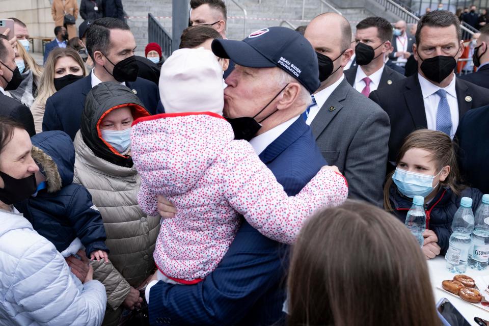 US President Joe Biden kisses a child while meeting refugees of Russia's war with Ukraine at PGE Narodowy Stadium in Warsaw, Poland on March 26, 2022. (Photo by Brendan Smialowski / AFP)